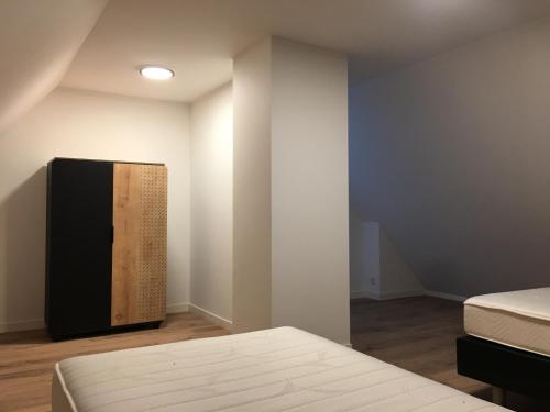 a room with two beds and a tv on the wall at Appartement Buiten de Veste 28 in Veere
