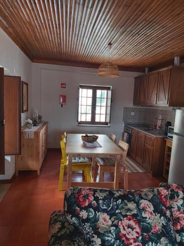 a kitchen and dining room with a table and a couch at Casa da Souropires in Pinhel