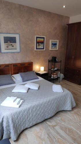 1 dormitorio con 1 cama grande con almohadas blancas en Bed & Breakfast CENTRALE, en Bolonia