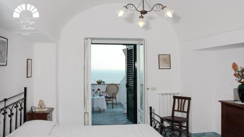 1 dormitorio con 1 cama y comedor con mesa en Al Poggio Antico, en Amalfi