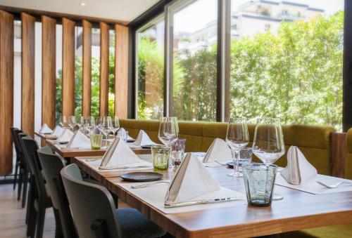 a row of tables with wine glasses and napkins at Hotel City Locarno in Locarno