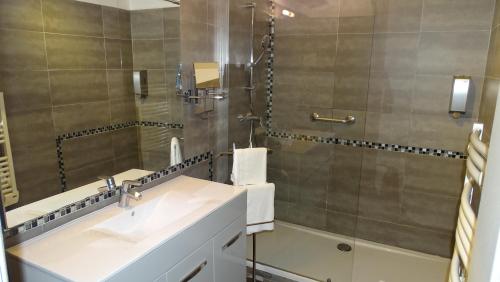 a bathroom with a sink and a shower at Logis Hotel des Granges in Arles