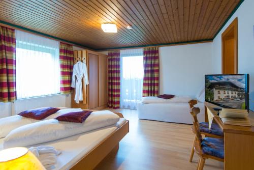 um quarto de hotel com duas camas e uma secretária e uma secretária em Salaterhof Embach em Lend