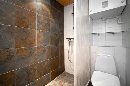La salle de bains est pourvue de toilettes et d'une douche carrelée. dans l'établissement Ski-Inn RukaTonttu, à Ruka