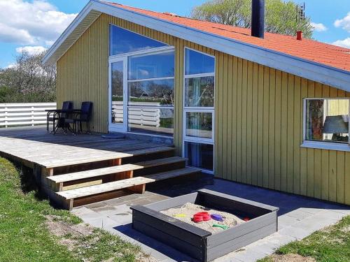 a green house with a deck and a patio at 6 person holiday home in Hemmet in Hemmet