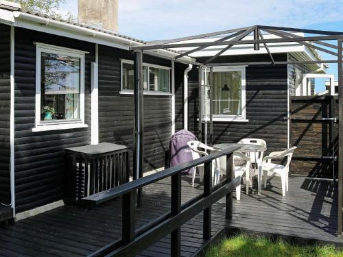 una terraza de madera con mesa y sillas. en 6 person holiday home in Storvorde, en Storvorde