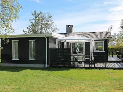 una casa negra con porche y terraza en 6 person holiday home in Storvorde, en Storvorde
