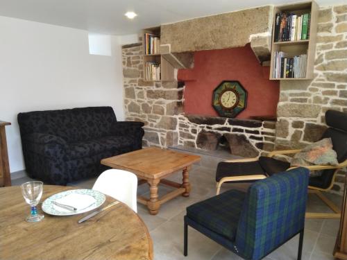 a living room with a couch and a table at Les charmantes pierres percées in Ploumilliau
