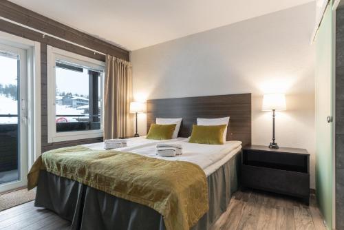1 dormitorio con 1 cama grande y 2 lámparas en Ski-Inn RukaValley en Ruka