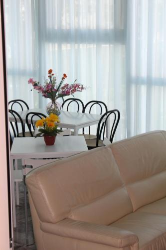 a living room with a couch and a table with flowers at Hotel San Paolo in Rimini
