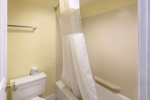 y baño con aseo y cortina de ducha. en Quality Inn New Orleans I-10 East en Nueva Orleans