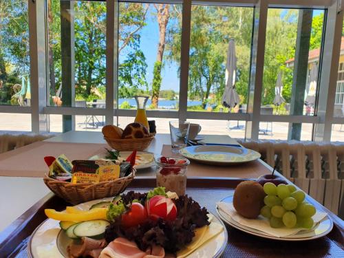 una mesa con platos de comida encima en Waldhotel am See Berlin-Schmöckwitz, en Berlín