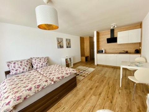 a bedroom with a large bed and a kitchen at Dream apartman in Bojnice