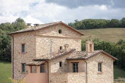 a stone house with two chimneys on top of it at Agriturismo Colle Casini Cortesi in Caldarola