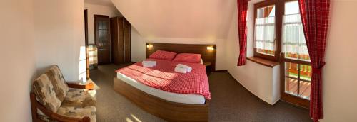 a bedroom with a bed with red sheets and red pillows at Chatky pri penzióne Pribiskô in Zuberec