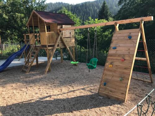 un parque infantil de madera con un tobogán y un columpio en Apartmány pod lanovkou, en Hořejší Vrchlabí
