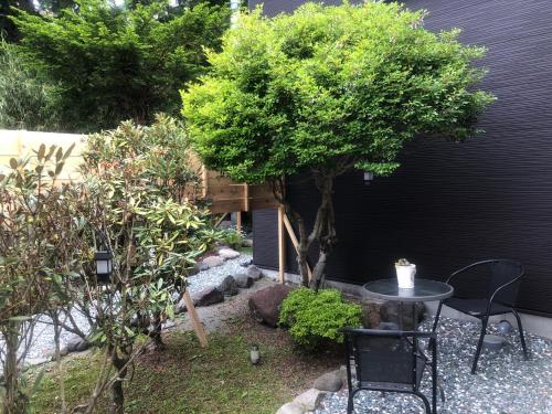 a small garden with a table and a tree at Stay Nikko Guesthouse in Nikko