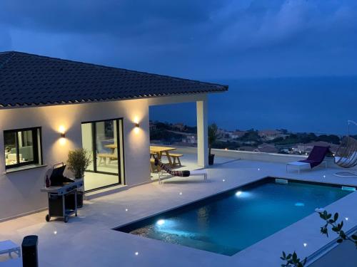 a villa with a swimming pool at night at Villa Mare d'argentu La solenzara in Sari Solenzara