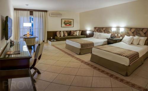 a hotel room with two beds and a couch at Hotel JP Ribeirão Preto Resort & Convenções by Nacional Inn in Ribeirão Preto