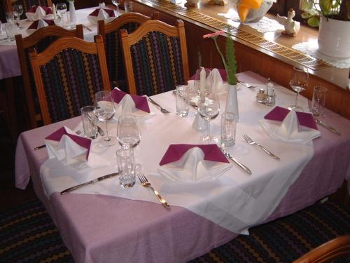 a table with a purple table cloth with napkins and wine glasses at Hotel Klausen in Pill