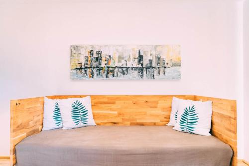 a bed with two pillows and a painting on the wall at Gut Hügle Erlebnishof in Ravensburg