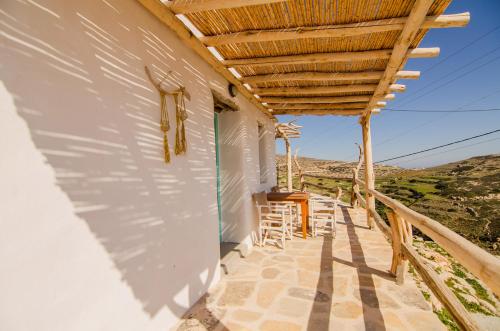 a porch of a house with a wooden roof at Dimitrakis Guesthouse in Donoussa