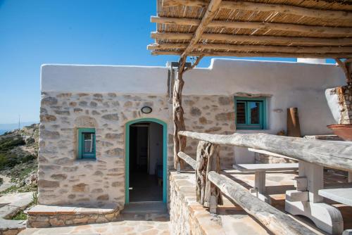 a white building with a green door and stairs at Dimitrakis Guesthouse in Donoussa