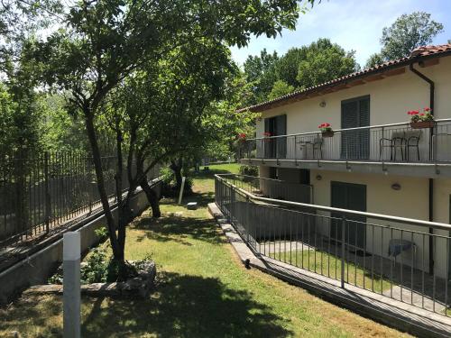 a house with a fence and a tree in the yard at B&B Oasi Vetoio in LʼAquila