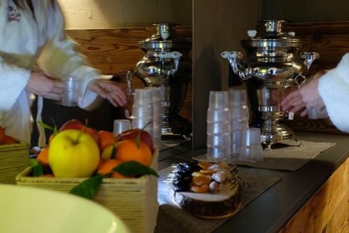 a counter with fruit and candles and a counter with food at La Roccia Wellness Hotel in Cavalese