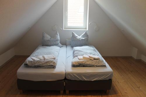 dwa łóżka w pokoju pod schodami w obiekcie Haus Seesturm w mieście Neßmersiel