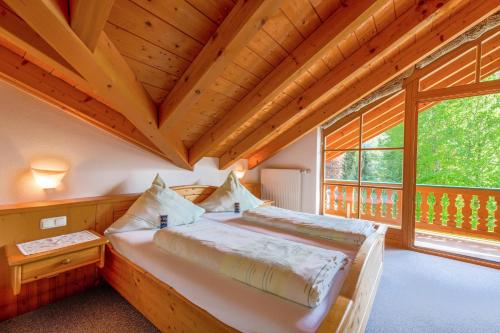 ein Schlafzimmer mit einem Bett und einem großen Fenster in der Unterkunft Petrushof Ferienwohnung Vogelspitz in Oberwössen