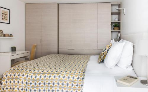 a small bedroom with a bed and a desk at Appartements - Le Logis Versaillais in Versailles