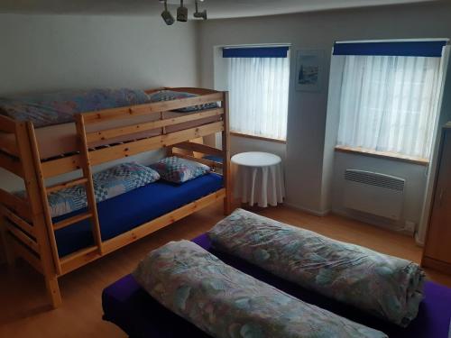 a bedroom with two bunk beds and a table at Ferienhaus Turba in Bivio