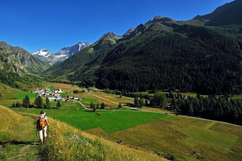 a person walking on a hill overlooking a valley at Club Alpina - Champagny-en-Vanoise in Champagny-en-Vanoise