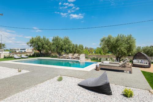 a swimming pool in a yard with a bench at "Four Olives" Luxury Rooms, Afitos #FeelsLikeHome in Afitos