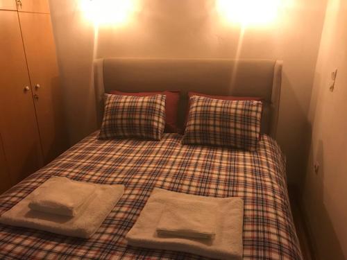 a bed in a small room with two pillows at The House in the Cobbled Road in Karpenision