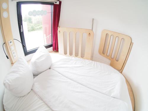 łóżko z białą pościelą w pokoju z oknem w obiekcie slube 25 Teiche Rottstock w mieście Rottstock