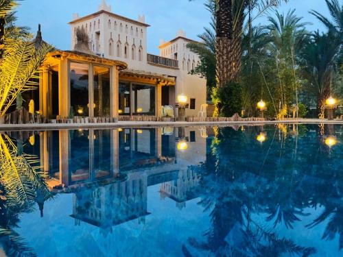 a resort with a swimming pool at night at Dar Hnini in Zagora