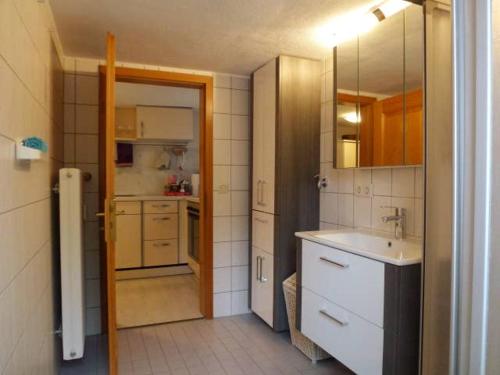 een kleine keuken met een wastafel en een spiegel bij Ferienwohnung Holl-Horn in Gaienhofen