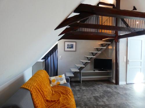 a living room with a staircase with a couch and a television at Auberge du Lac in Mandailles