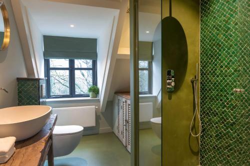 uma casa de banho com um chuveiro, um lavatório e um WC. em Parkhotel Abcoude em Abcoude
