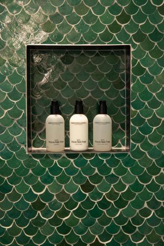 three bottles of soap on a shelf on the wall at Parkhotel Abcoude in Abcoude