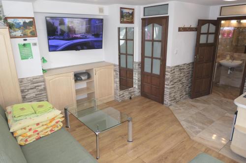 a living room with a tv and a glass table at Apartamenty u Łukasza in Zakopane