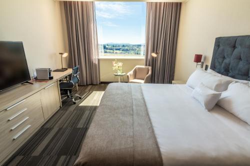 a hotel room with a large bed and a flat screen tv at MDS Hotel Chillan in Chillán