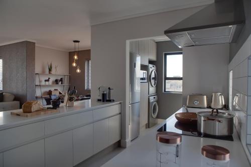 a kitchen with white cabinets and a counter top at Waters Edge Apartments in Cape Town