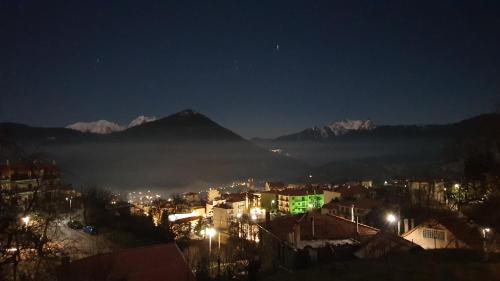 a city at night with a mountain in the background at The House in the Cobbled Road in Karpenision