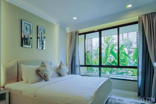 a bedroom with a bed and a large window at Marrakesh Huahin 1 bedroom with pool access 307 in Hua Hin