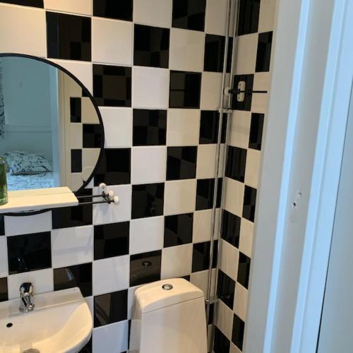 a bathroom with a black and white tiled wall at Hedmansgården in Västra Torp