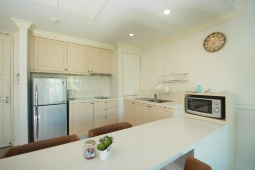 a kitchen with a counter and a clock on the wall at Marrakesh Huahin 1bedroom with seaview 148 in Hua Hin