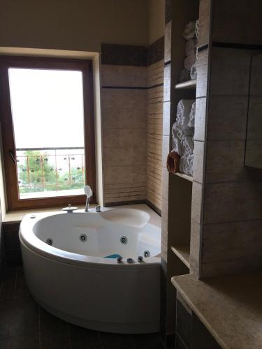 a large white tub in a bathroom with a window at Amazing Place in Afitos